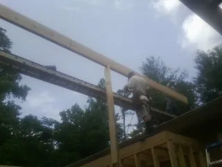 Carpenter setting a ridge beam over a new addition frame — Ice Dam Removal by Roofing Brothers in Missouri Valley