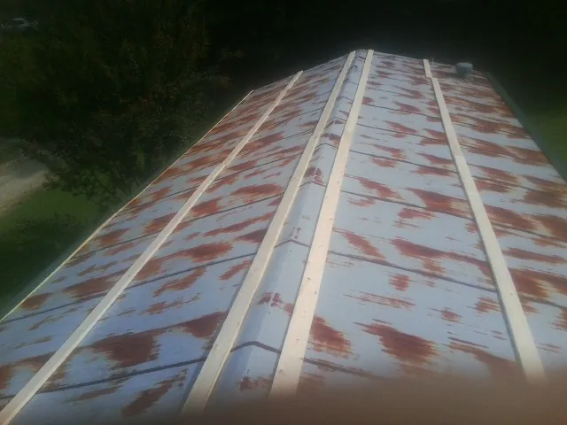 Rusted metal roof panels with new wood purlins before replacement — Storm Damage Roof Repair in Missouri Valley by Roofing Brothers