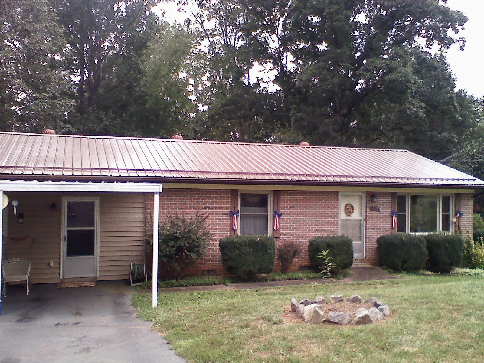 Bronze metal roof and carport on a brick ranch home — Roof Repair work by our crew in Missouri Valley